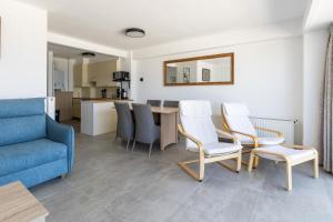 een woonkamer met een bank, een tafel en stoelen bij Santa Rosa in Blankenberge +9 foto's
