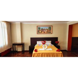 a hotel room with a bed with flowers on it at Hostal Bless Tacna in Tacna
