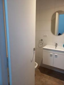 ein Badezimmer mit Waschbecken, Toilette und Spiegel in der Unterkunft Rincón del cielo in Mar del Plata + 5 Fotos