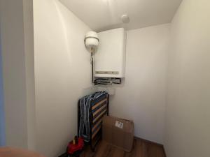 a room with a white wall with a light and a box at Apartment Sonnenberg in Hallein