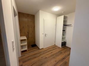 an empty room with a white door and wooden floors at Apartment Sonnenberg in Hallein