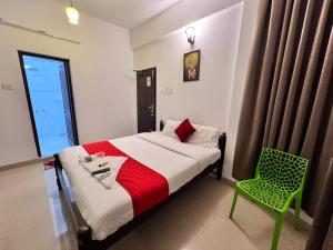 Palm Beach Resort, Alleppey في أليبي: غرفة نوم بسرير وكرسي أخضر +43 صورة