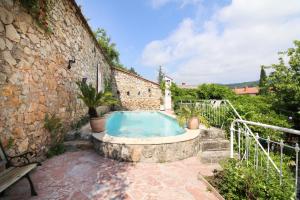 a swimming pool in a stone building with a stone wall at La Roseraie in Lodève