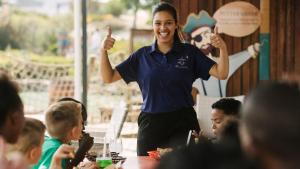 Een vrouw steekt haar duim omhoog terwijl ze voor een groep kinderen staat. bij Swallows Rest - Benguela Cove in Hermanus +66 foto's