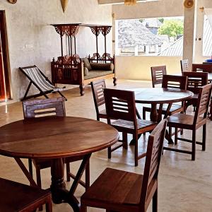 a room with tables and chairs and a couch at AMOODY MANZIl in Shela