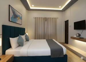 バラナシにあるHotel Valencia Innのベッドとテレビがあるホテルの部屋