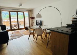 Apartment Schliersee - Stylisch, zentral, familienfreundlich في شليرزيه: غرفة معيشة مع طاولة وكراسي ومطبخ