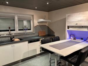 Cozy 2-room non-smoking apartment في بينسهايم: مطبخ مع طاولة وكراسي في الغرفة