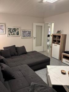 Cozy 2-room non-smoking apartment في بينسهايم: غرفة معيشة بها أريكة وطاولة