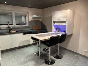 Cozy 2-room non-smoking apartment في بينسهايم: مطبخ فيه طاولة وكرسيين