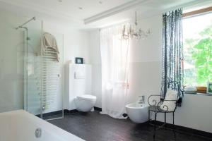 ein Badezimmer mit Badewanne, Toilette und Fenster in der Unterkunft Elbenow in Losenrade + 36 Fotos