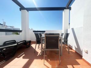 een balkon met een tafel en stoelen op een dak bij Las Terrazas Golf Cédric in Torre-Pacheco