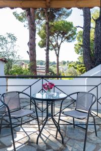 a table and chairs on a balcony with trees at Villa Nikos Koukounaries in Koukounaries