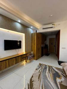 ein Wohnzimmer mit einem Flachbildfernseher an der Wand in der Unterkunft GAUR Luxury Stay in Ghaziabad