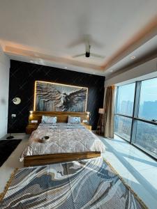 ein Schlafzimmer mit einem großen Bett und einem großen Fenster in der Unterkunft GAUR Luxury Stay in Ghaziabad + 16 Fotos