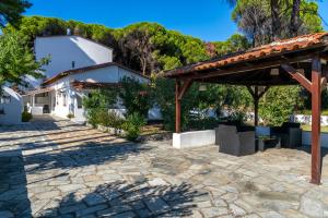 a patio in front of a white building with a pavilion at Villa Nikos Koukounaries in Koukounaries