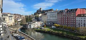a view of a city with a river and buildings at Le Charme du Sanctuaire 8 couchages 400m de la Grotte in Lourdes