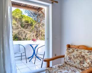 a room with a door open to a balcony with a table at Villa Nikos Koukounaries in Koukounaries +46 photos