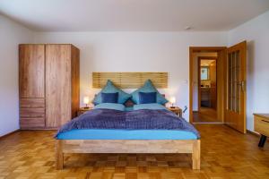 una camera da letto con un letto blu con cuscini blu di Brandenkopfblick a Oberharmersbach