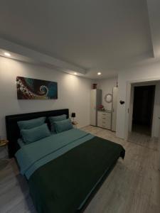 a bedroom with a large bed with a green blanket at Lucas investment L3 -104 in Creţuleasca