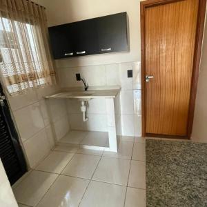 Un baño con lavabo y puerta de madera. en Raízes Hotel, en Cajobi