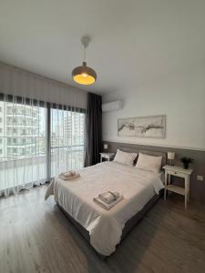 a bedroom with a large bed and a large window at Caesar Resort & SPA - Rahat & Konforlu Daireler in Iskele