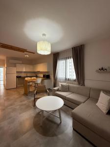 a living room with a couch and a table at Caesar Resort & SPA - Rahat & Konforlu Daireler in Iskele