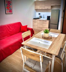 a living room with a table and a red couch at LOFT EMILIA a Castel Bolognese self check-in in Castel Bolognese