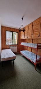 Rifugio dei Pini في روكاراسو: غرفة بسريرين بطابقين ونافذة