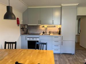 a kitchen with white cabinets and a wooden table at Huså byskola in Järpen