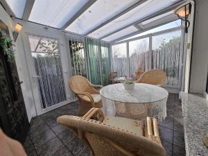 a screened in porch with a table and chairs at Ferienhaus Alla, Neeberg/Usedom in Neeberg