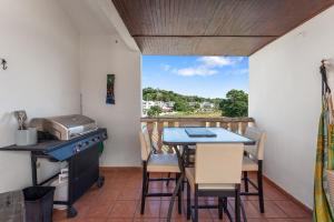 a balcony with a table and chairs and a kitchen at Costa Ensenada Penthouse 505 across the street from Balneario beach in Rincon