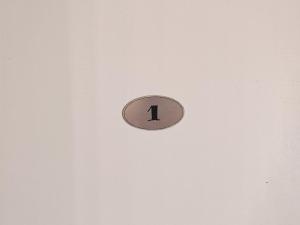 a clock on a wall with the number one on it at KONDOR apartmani in Vrnjačka Banja