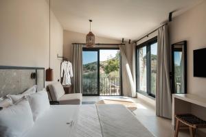 a bedroom with a bed and a large window at Olivera Suites Sarti in Sarti