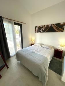 a bedroom with a bed and a large window at Maison en Provence avec terrasse privée - Fibre TV in Lambesc