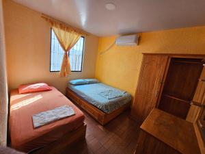 a small bedroom with two beds and a window at Villa cerca al malecón de Salinas para 10 personas in Salinas +21 photos