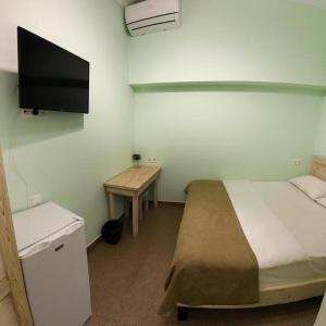 a bedroom with a bed and a television on the wall at Americana By California in Yerevan