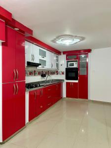 a red kitchen with white walls and red cabinets at Casa full Confort en el corazón de valledupar in Valledupar