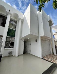a white house with white columns at Casa full Confort en el corazón de valledupar in Valledupar