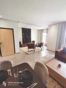 Una sala de estar con una mesa y sillas y un sofá. en فندق لوريت, en Qaryat at Ta‘mīr as Siyāḩīyah