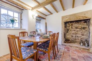 een eetkamer met een tafel en stoelen en een open haard bij 2 Bed in Ashover oc-c33546 in Ashover