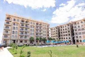 a large building with a lawn in front of it at فندق لوريت in Qaryat at Ta‘mīr as Siyāḩīyah