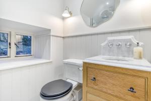 een badkamer met een toilet, een wastafel en een spiegel bij 2 Bed in Ashover oc-c33546 in Ashover +13 foto's