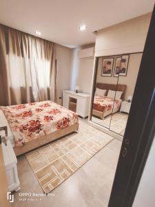 un dormitorio con una cama y un espejo en فندق لوريت, en Qaryat at Ta‘mīr as Siyāḩīyah