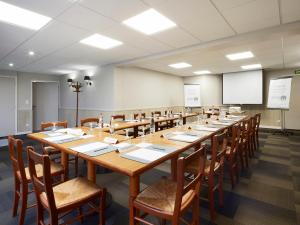 une grande salle de conférence avec une grande table et des chaises dans l'établissement Campanile Le Mans - Arnage, à Arnage