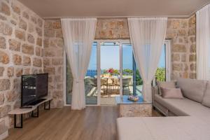 a living room with a couch and a large window at Olive Resort in Petrovac na Moru