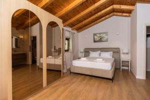 a bedroom with a large bed and a bathroom at Olive Resort in Petrovac na Moru