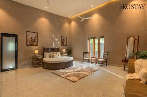 a large bedroom with a bed and a chair at EKOSTAY - The Clay House in Alibaug