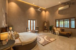 a bedroom with a large bed and a living room at EKOSTAY - The Clay House in Alibaug +16 photos