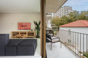 ein Balkon mit einer Couch und einem Fernseher auf einem Gebäude in der Unterkunft GuestReady - DPV Residences in Porto